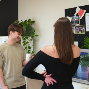 Click Click Media team members chat and laugh around a meeting table in the agency's bright Norwest office.
